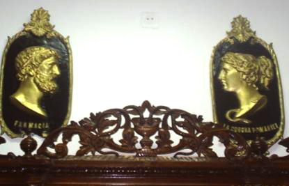 Emblema Farmaciei La Coroana Romaniei, a farmacistului Alexandru Nagy, Targoviste, a doua jumatate a secolului al XIX-lea; Medalioane decorative cu efigiile lui Esculap si a Higeei
